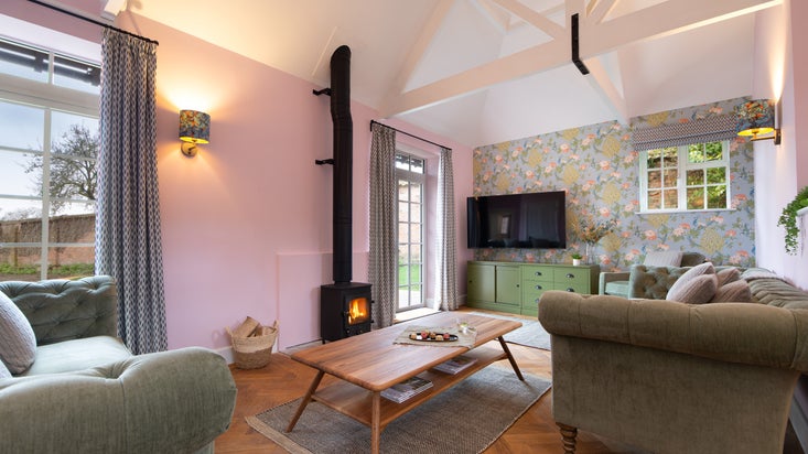 The sitting room has a woodburner and doors that open onto the garden patio at The Weir Garden Cottage, Herefordshire